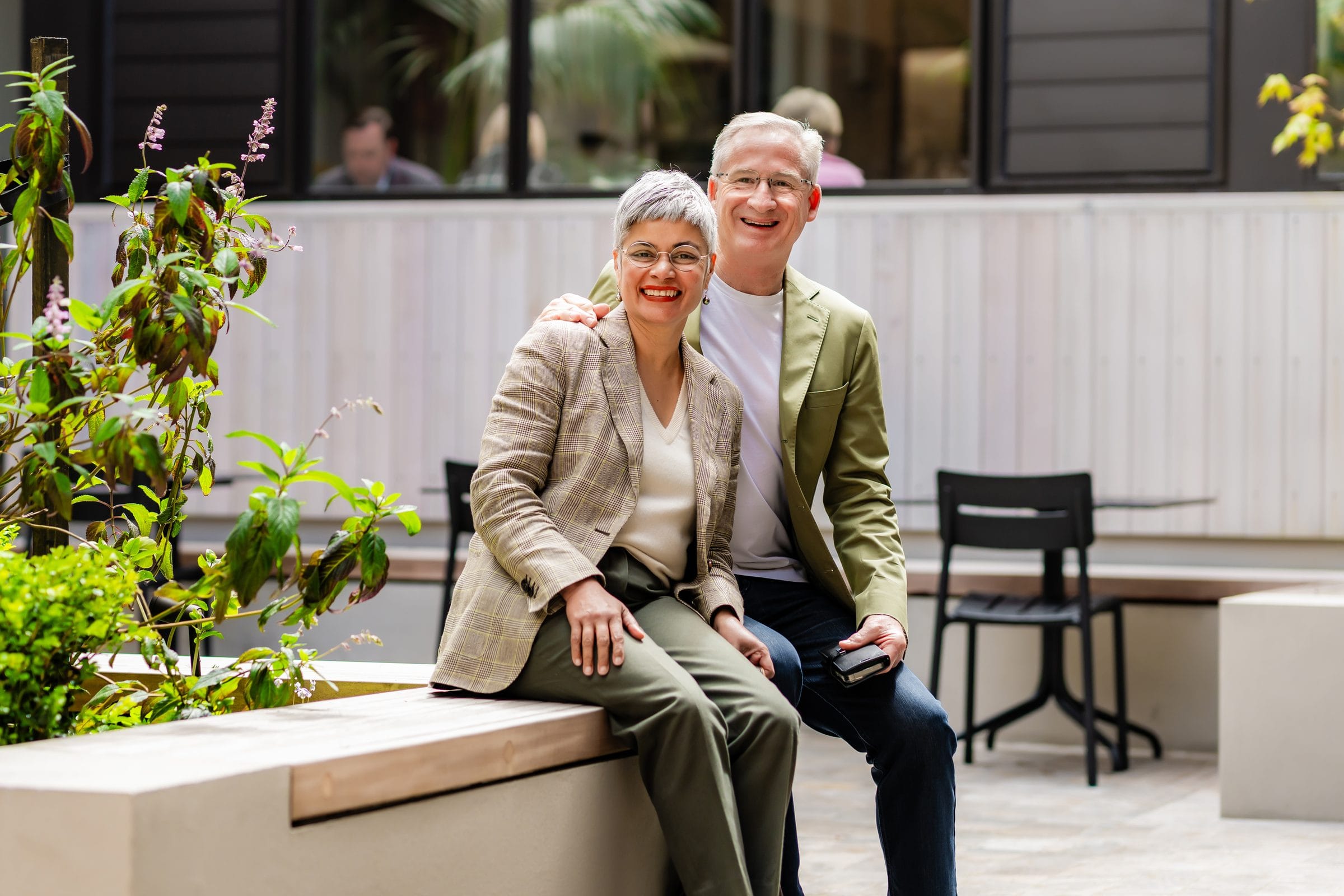 Steve and Nila Koerber sitting together on a courtyard bench