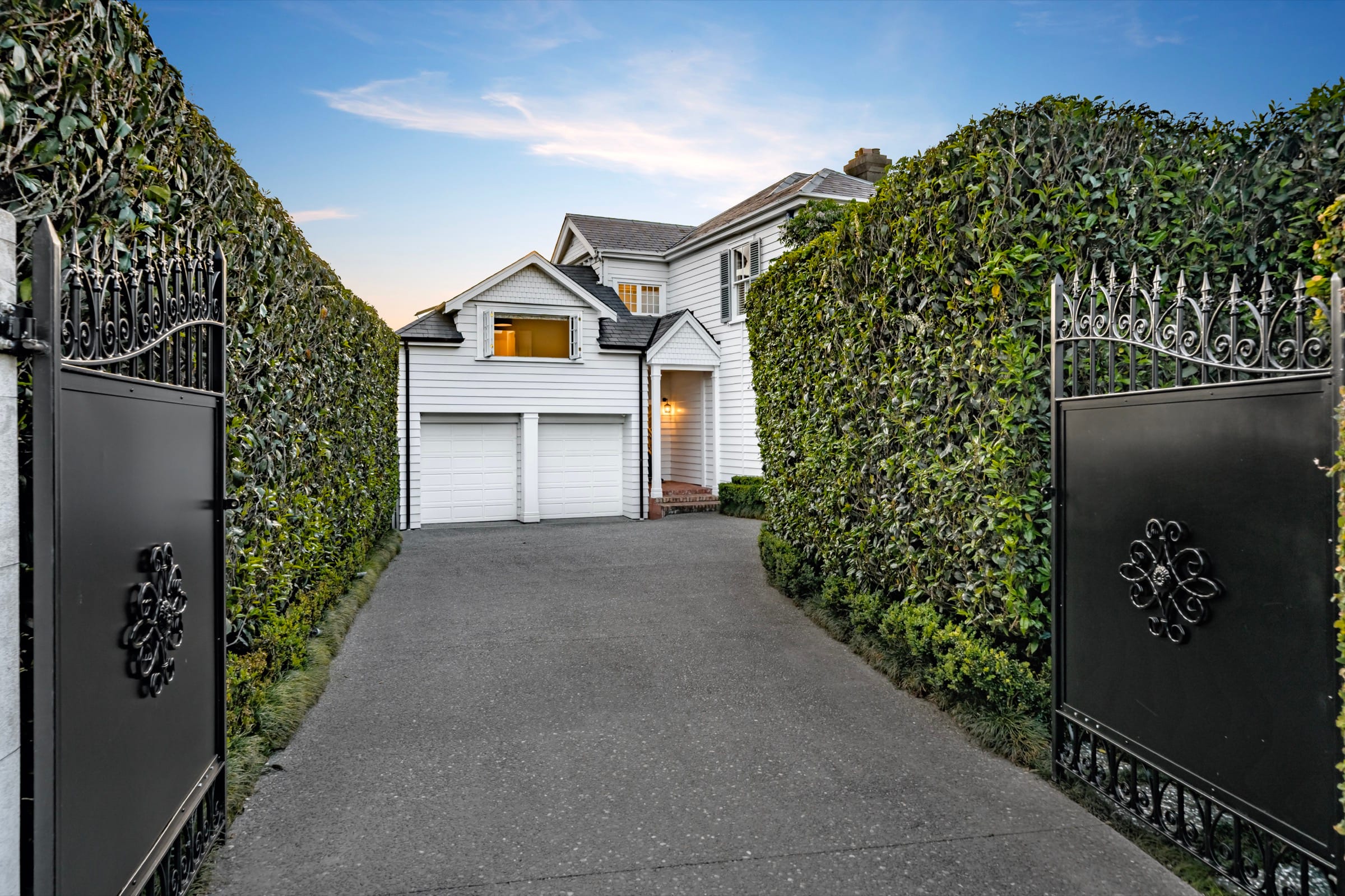 The iron gates and front garden of 52 Bassett Road at dusk
