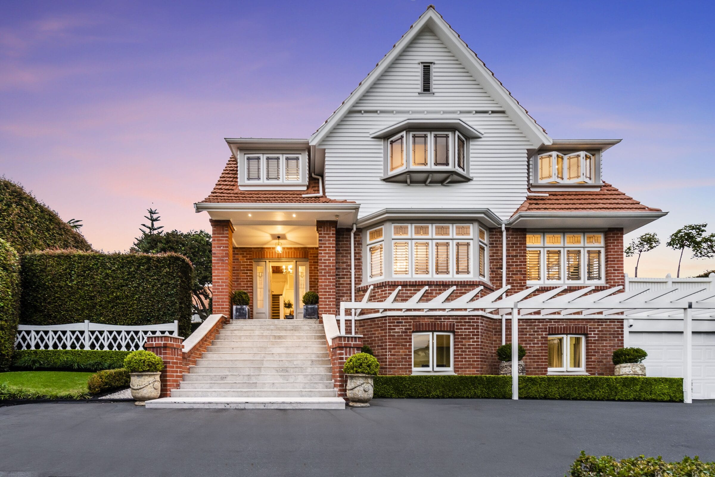 44 Entrican Avenue at dusk, a gabled brick and weatherboard home above its entrance steps