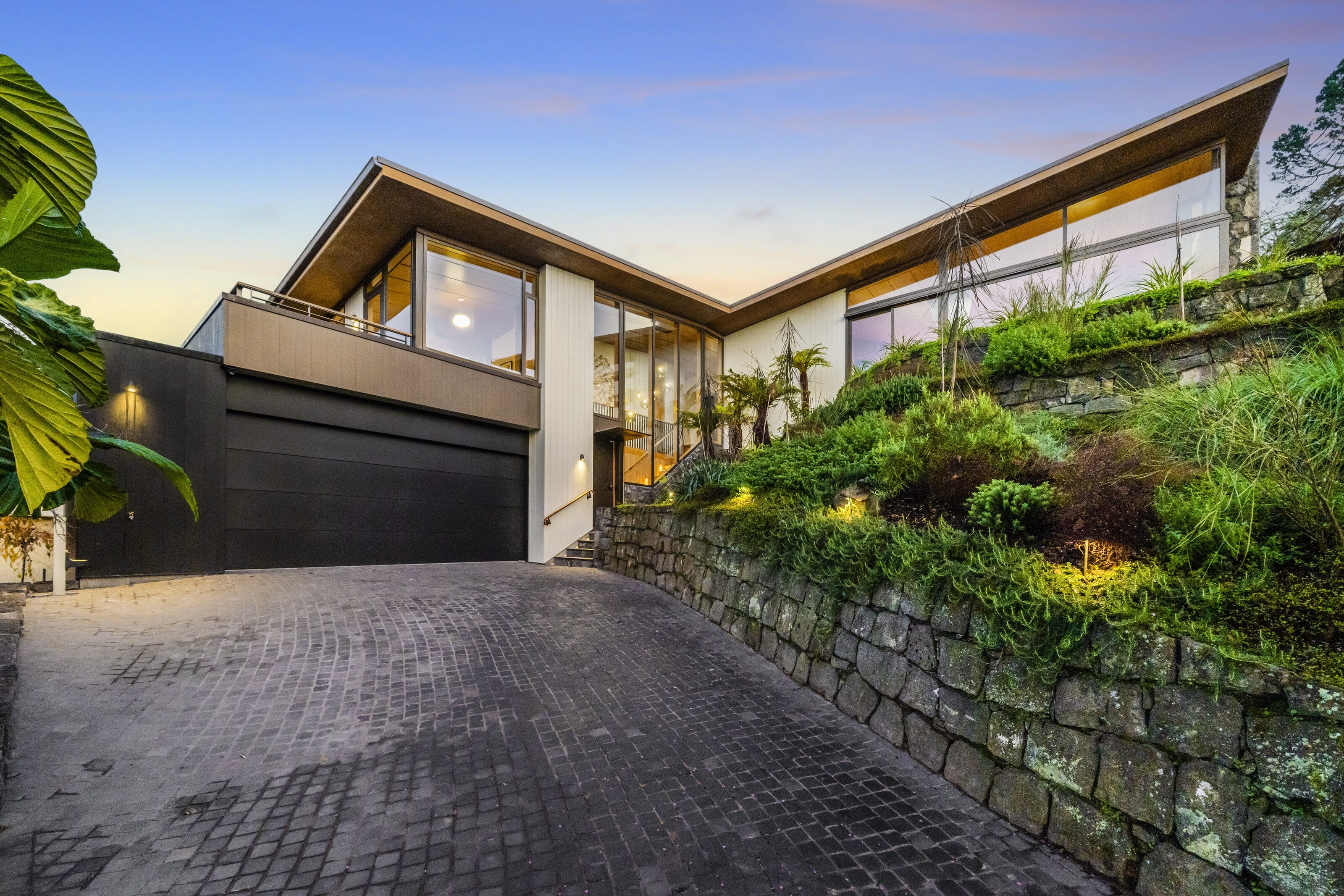 33 Market Road at dusk, the cedar roofline above its stone-paved drive