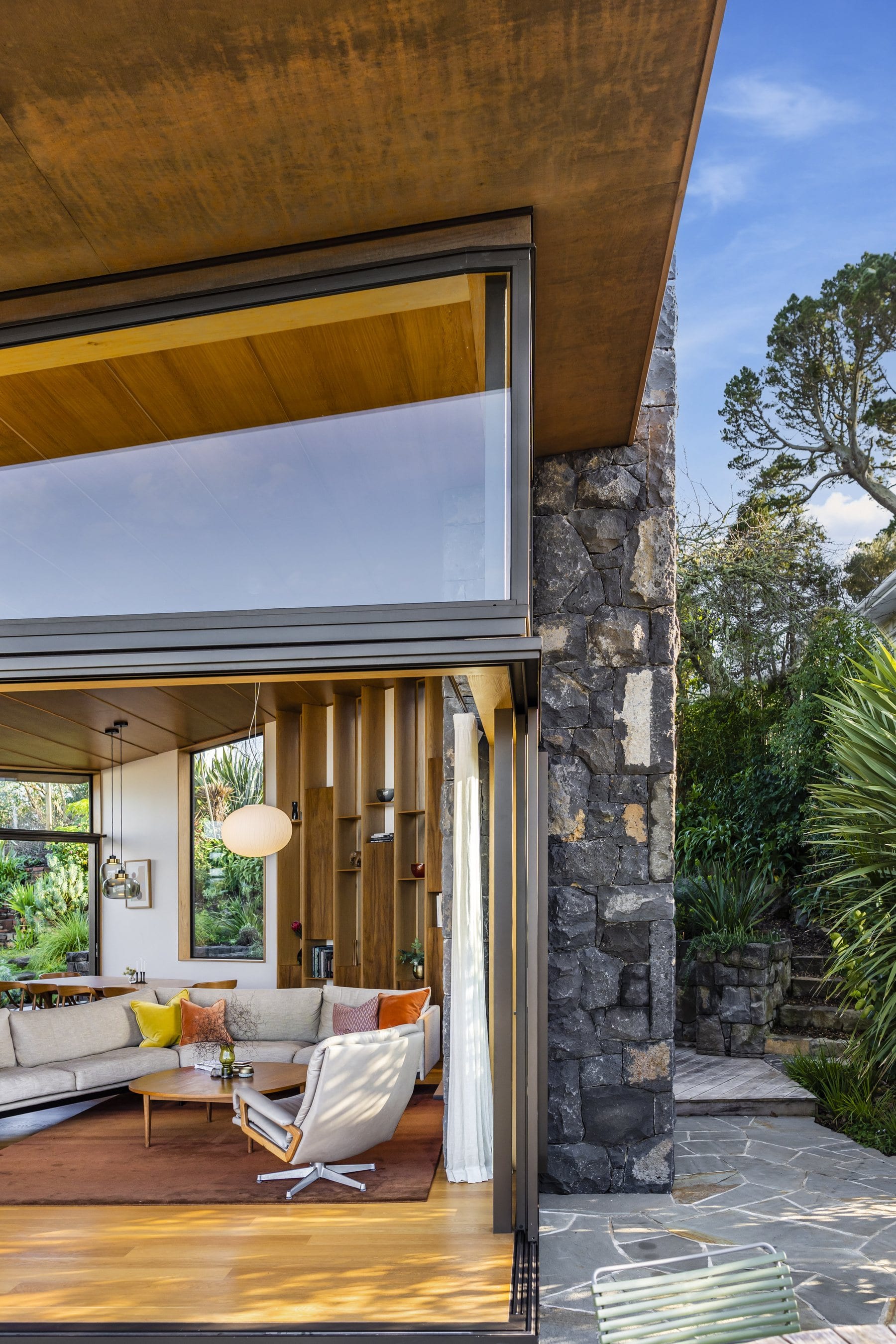 The stone chimney wall and the living room behind glass at 33 Market Road