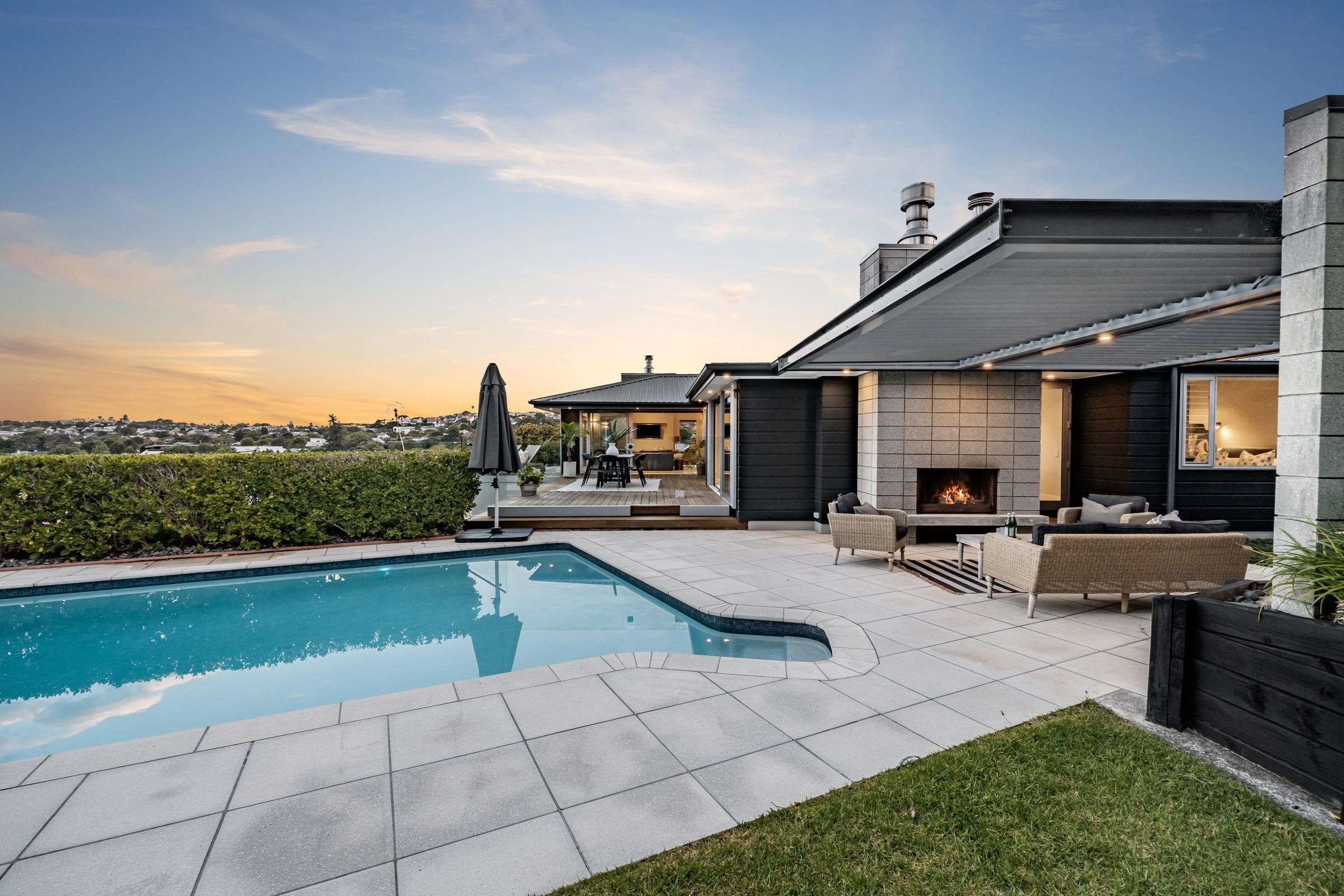 56 Ngapuhi Road, the pool terrace and outdoor fireplace at dusk
